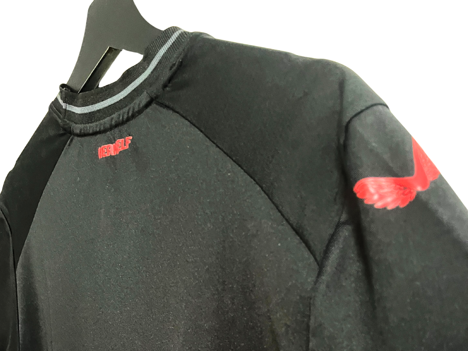 Détail de l’épaule du maillot Bayer Leverkusen VAPOR 2023/2024 noir et rouge, avec logo ailé rouge sur la manche.