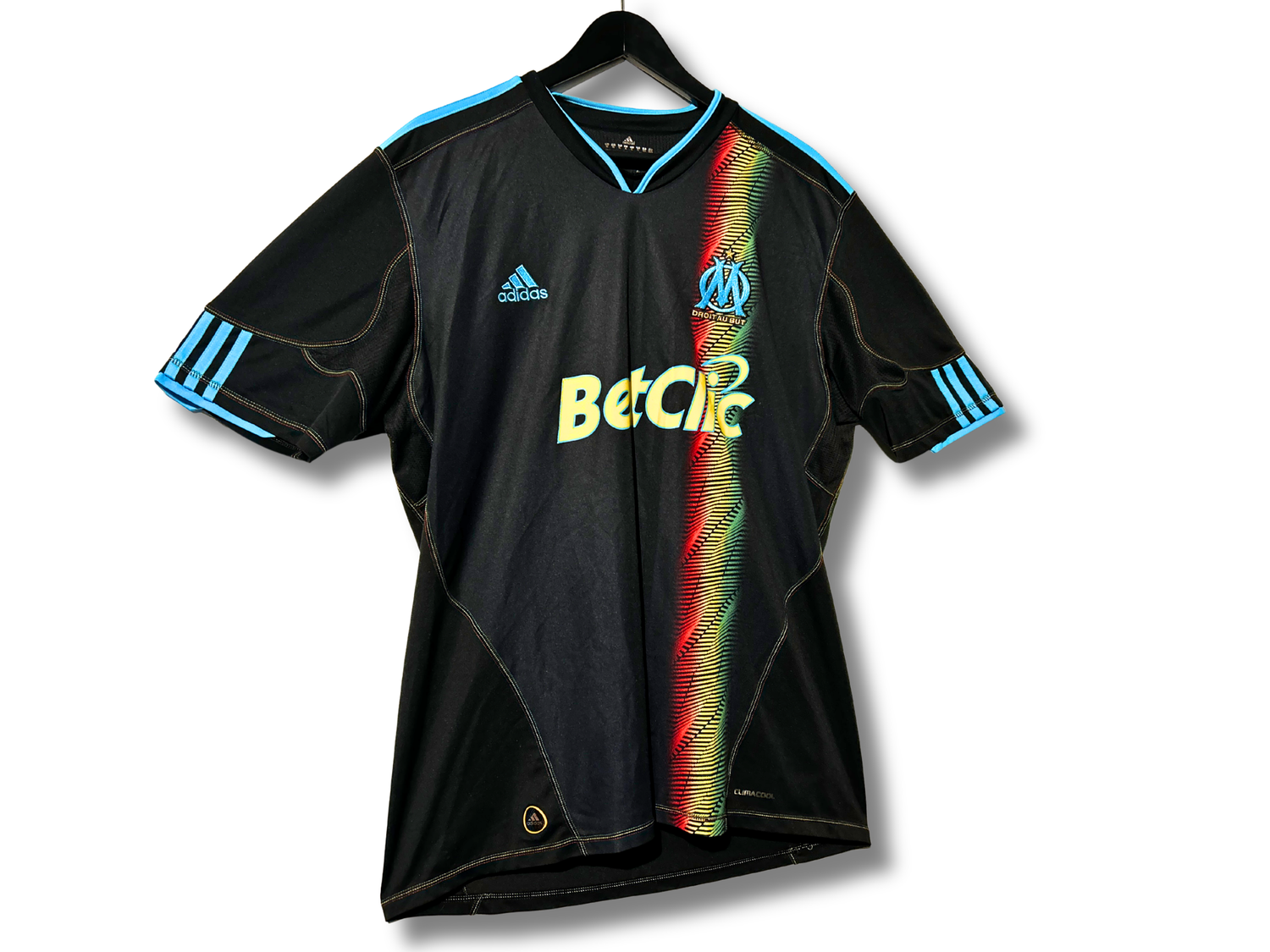 Écusson Droit Au But et logo Adidas doré sur maillot carreaux